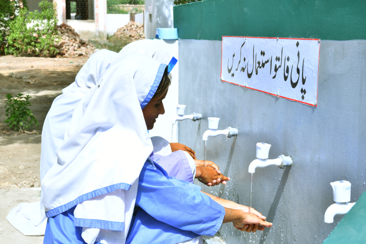 Textile workers washing their hands, highlighting the impact of water scarcity in fashion supply chains.
