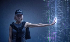 A woman leans against a wall of code, representing the way the fashion industry is keeping AI at arm's length.