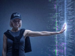 A woman leans against a wall of code, representing the way the fashion industry is keeping AI at arm's length.